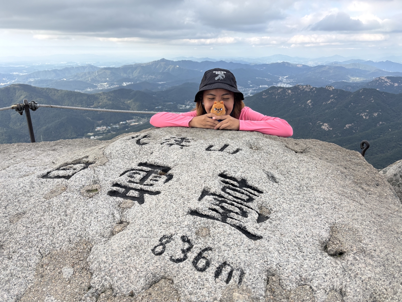 Melanie Hingpit from the Philippines poses with a stuffed animal representing a Stray Kids member at the summit of Bukhansan National Park in Seoul during her October hike. (Melanie Hingpit)
