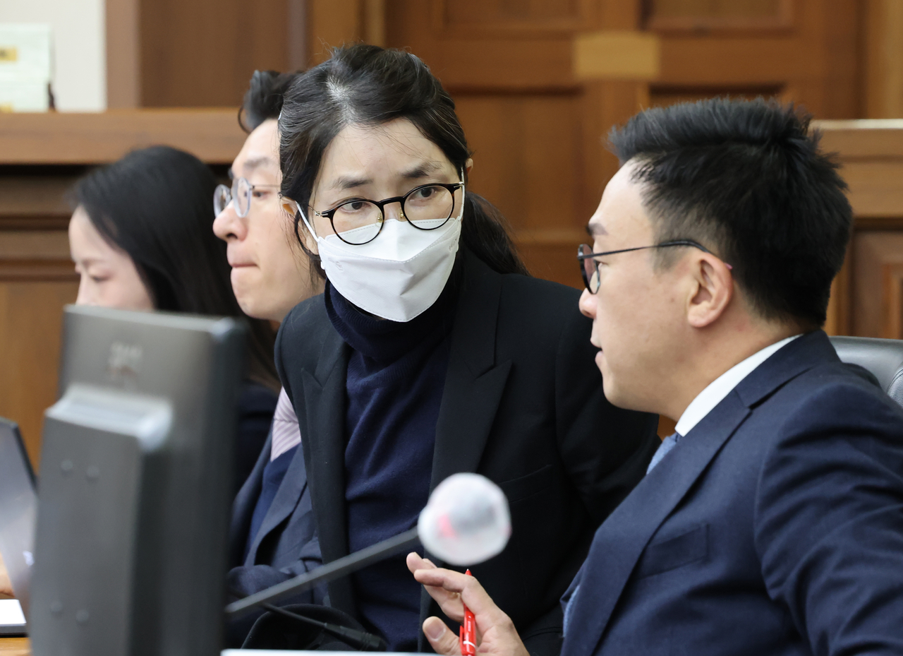 Kim Keon Hee (second from right) speaks with her lawyer during a hearing in her criminal trial Wednesday at the Seoul Central District Court. (Yonhap)