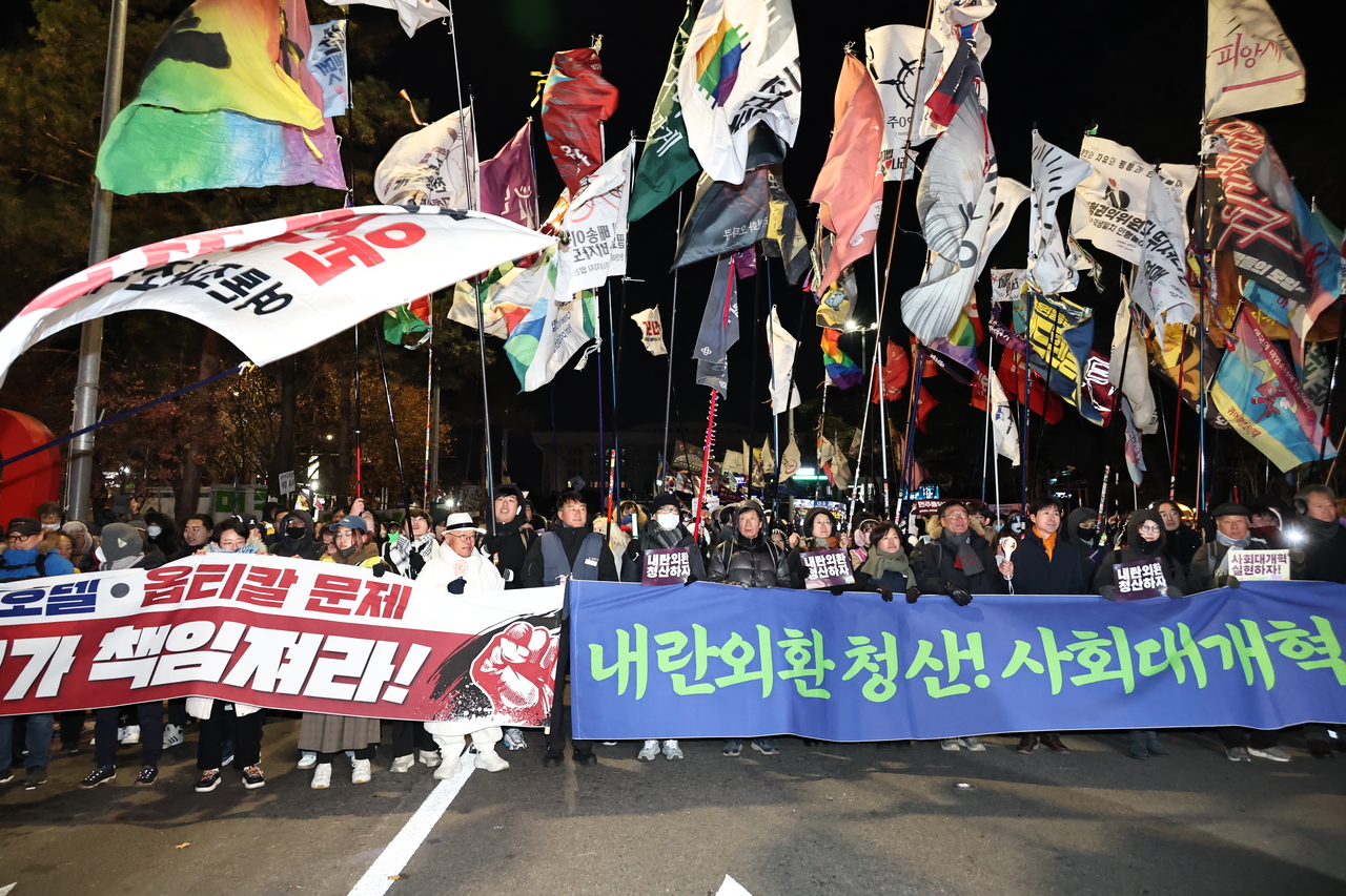 Participants march in a rally marking the first anniversary of the Dec. 3 martial law declaration, held in front of the main gate of the National Assembly in Yeouido, Seoul, on Wednesday. (Yonhap)