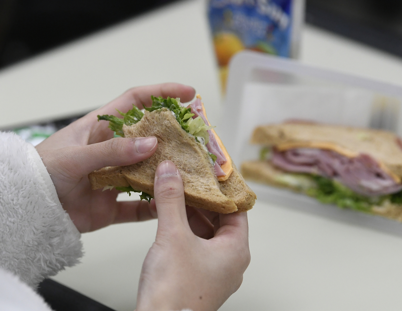 A student at a school in Gyeonggi Province eats a packaged sandwich provided for lunch after cafeteria operations were suspended due to a strike by kitchen workers on Thursday. (Yonhap)